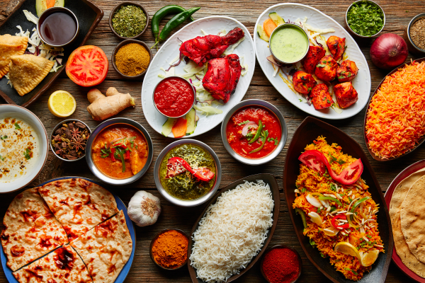 Assorted Indian recipes food various with spices and rice on wooden table